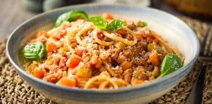 Spaghetti auf Teller mit Tomatensoße und Gemüse