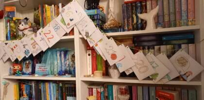 Bücherregal mit Adventskalender und Dekorationen.