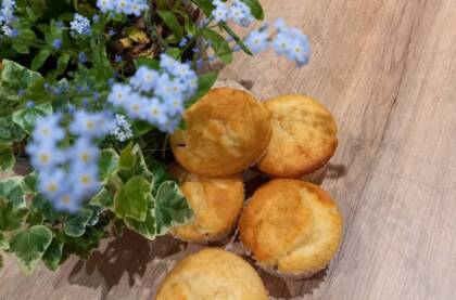 Zitronenmuffins und Blümchen auf Holztisch