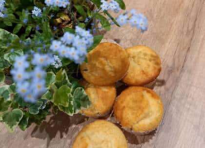 Zitronenmuffins und Blümchen auf Holztisch
