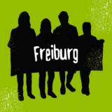 Gruppe von Menschen mit Freiburg-Schild.