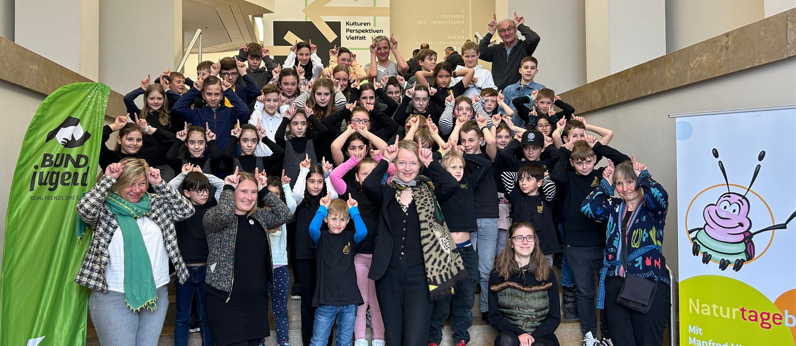 Gruppe von Kindern und Erwachsenen auf Treppe.