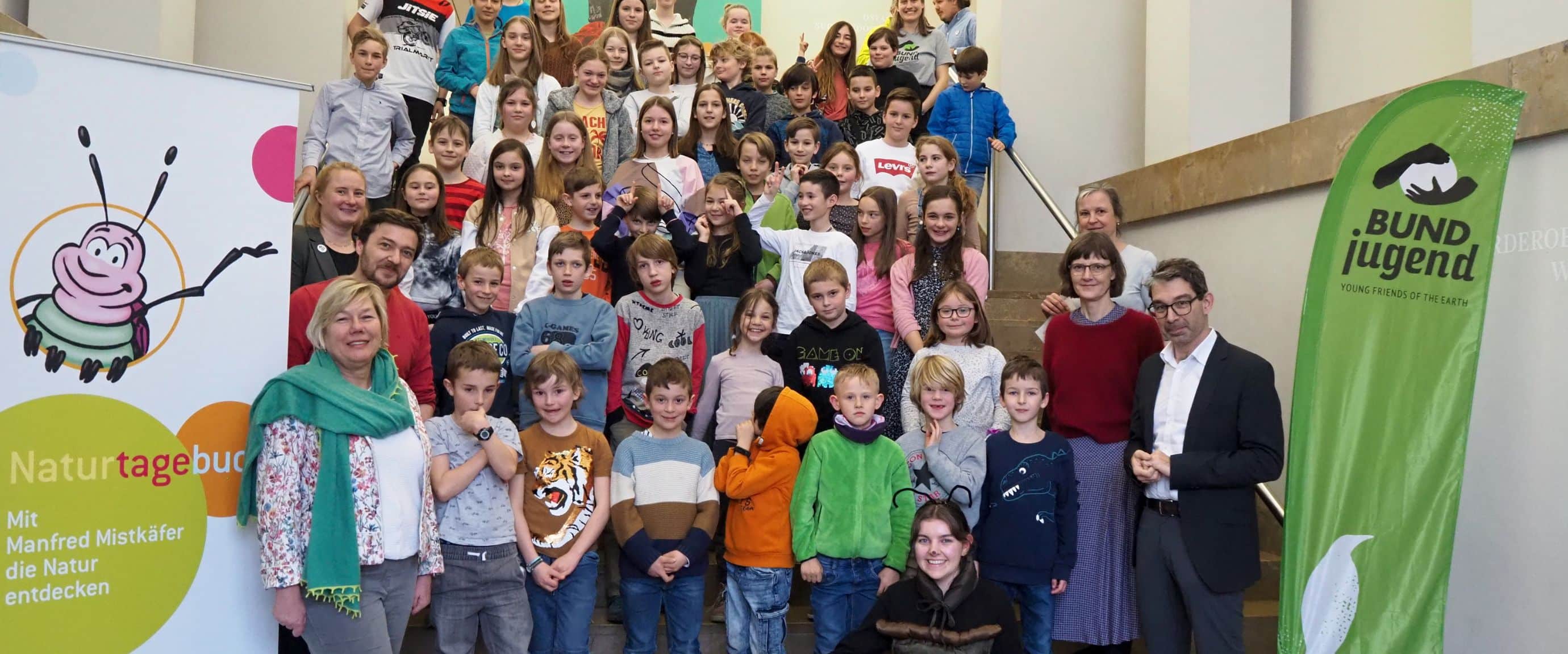 Gruppe von Kindern und Erwachsenen auf Treppe.