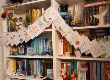 Farbenfroher Adventskalender vor Bücherregal