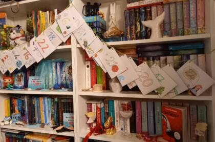 Farbenfroher Adventskalender vor Bücherregal