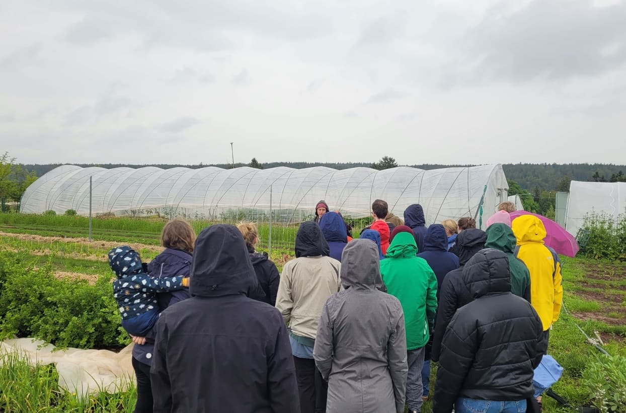 Menschen bei einer Führung auf einem Bauernhof.
