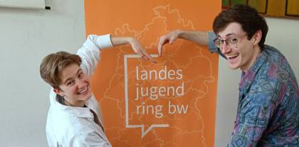 Jugendliche posieren vor Landesjugendring BW Plakat.
