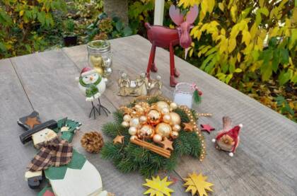 Weihnachtliche Dekoration auf Holztisch im Garten