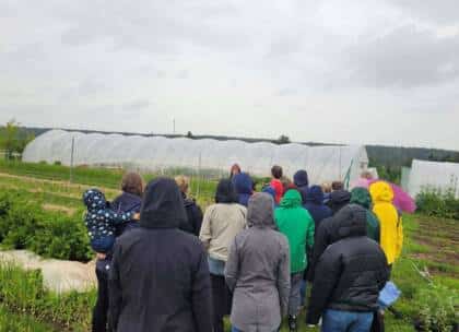Menschen bei einer Führung auf einem Bauernhof.
