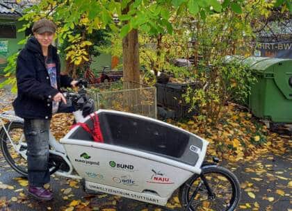 Person mit Lastenrad im Herbstlaub