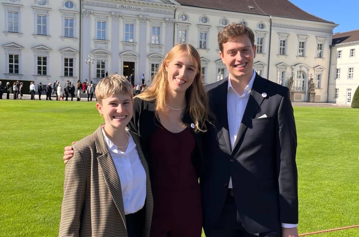 Drei Personen vor dem Schloss Bellevue.