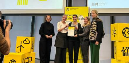 Gruppenfoto mit Zertifikat und nachhaltiger Strategie.